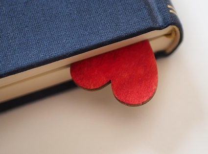 Photo of a hardcover book with a red heart as a bookmark